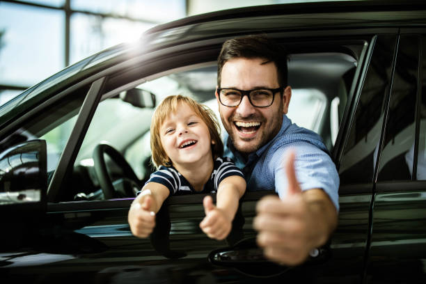 Photo d'un père et son fils heureux dans une voiture familiale.